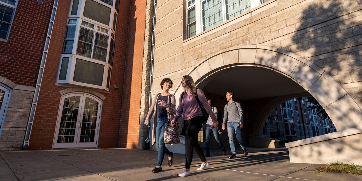 Students walk under arch in suite apartments