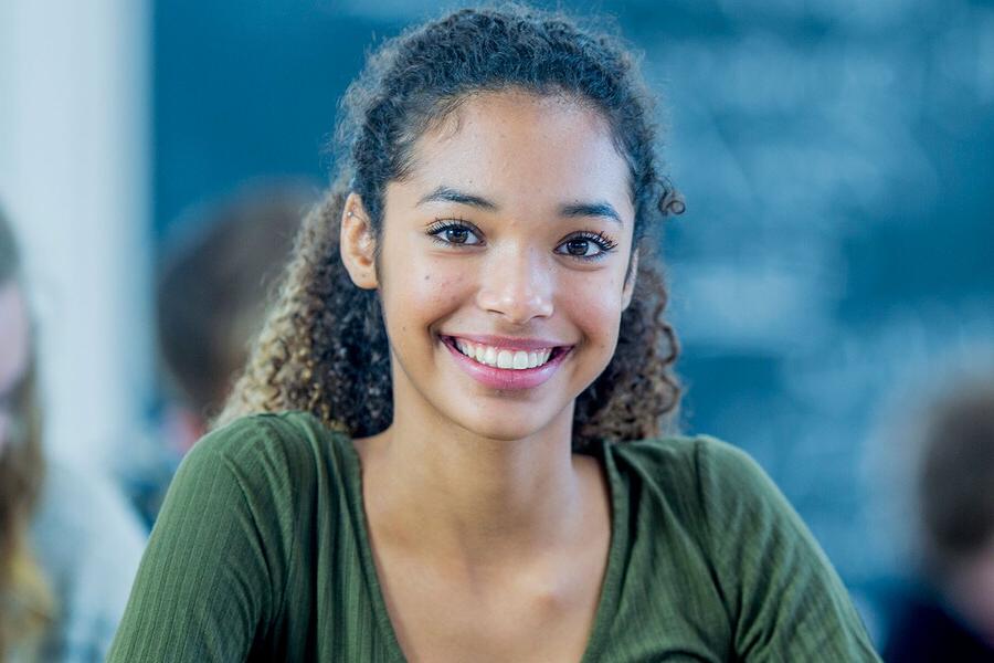 student in a classroom smiling