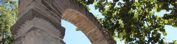 The legendary NWU arch juxtaposed by green trees and blue sky. 